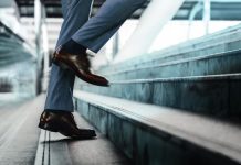 Motivation and challenging Concept. Steps Forward into a Success. Low Section of Businessman Walking Up on Staircase.